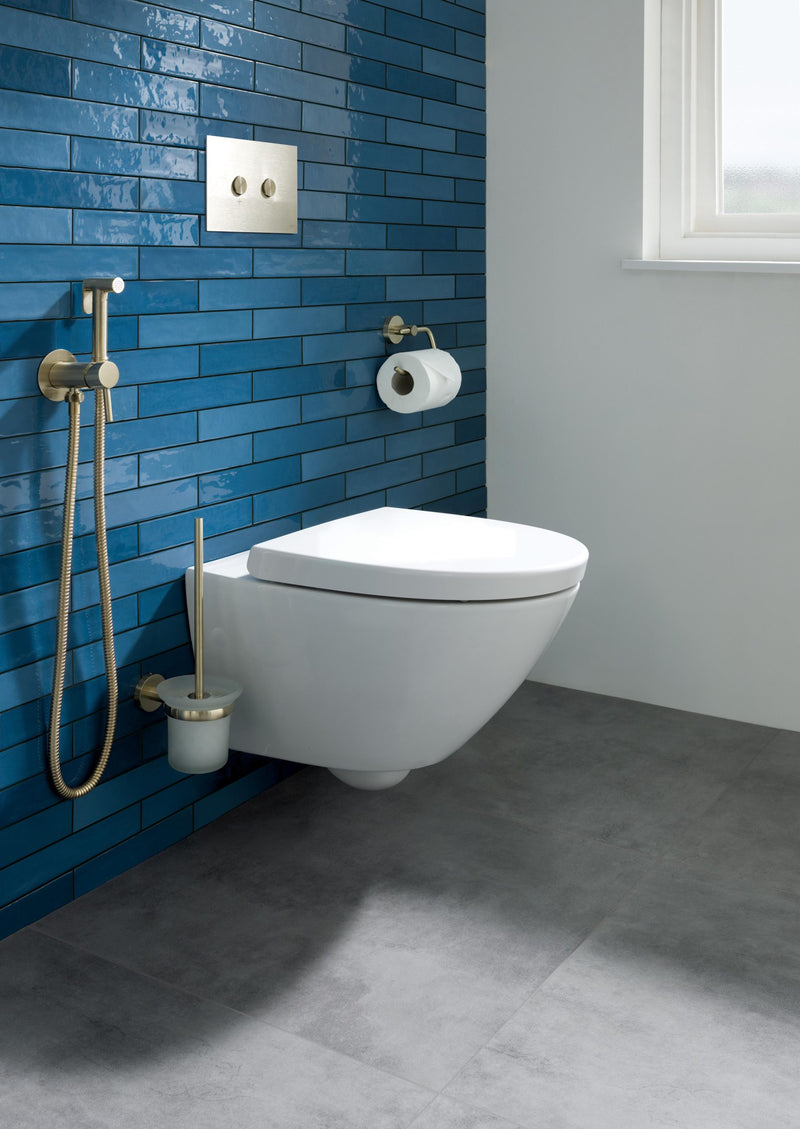 JTP VOS gold toilet roll holder mounted on bathroom wall, modern accessory for holding toilet paper rolls.