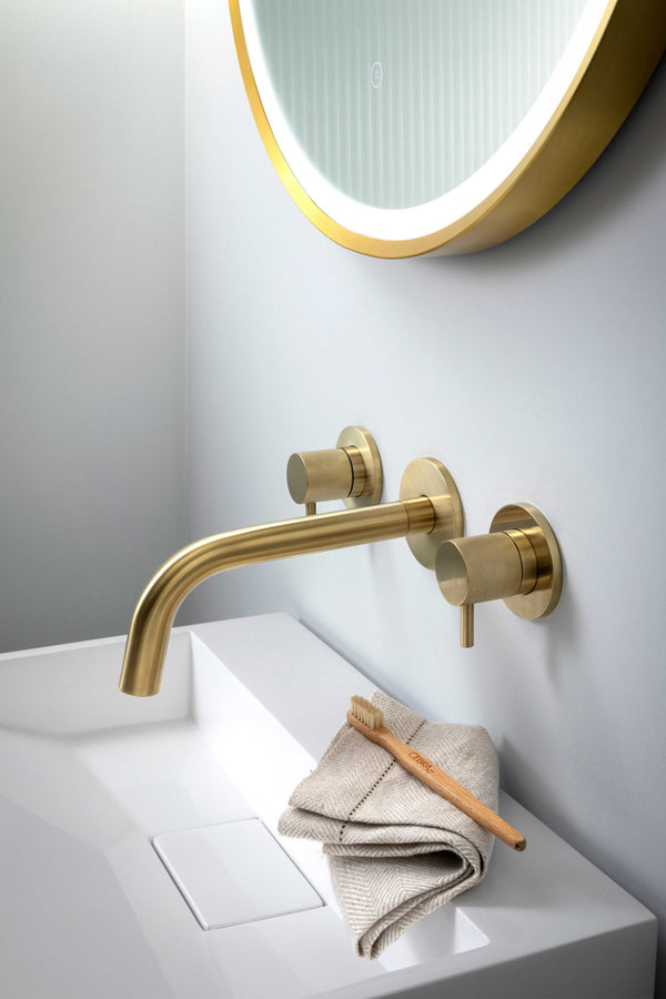 JTP VOS 3-hole wall mounted bath and basin filler with designer handle in brushed brass, shown with sleek modern design.
