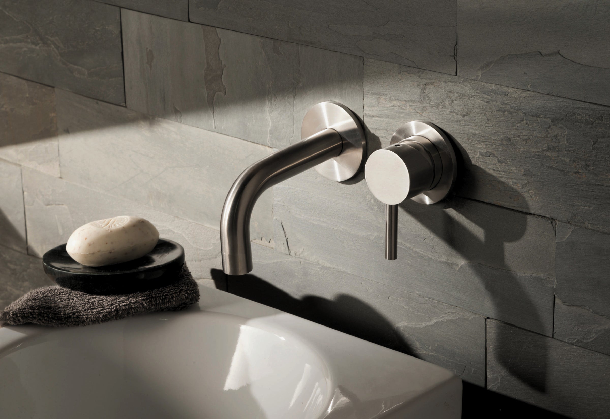 JTP single lever wall-mounted basin mixer tap with sleek chrome finish, mounted on a bathroom sink for modern style and easy control